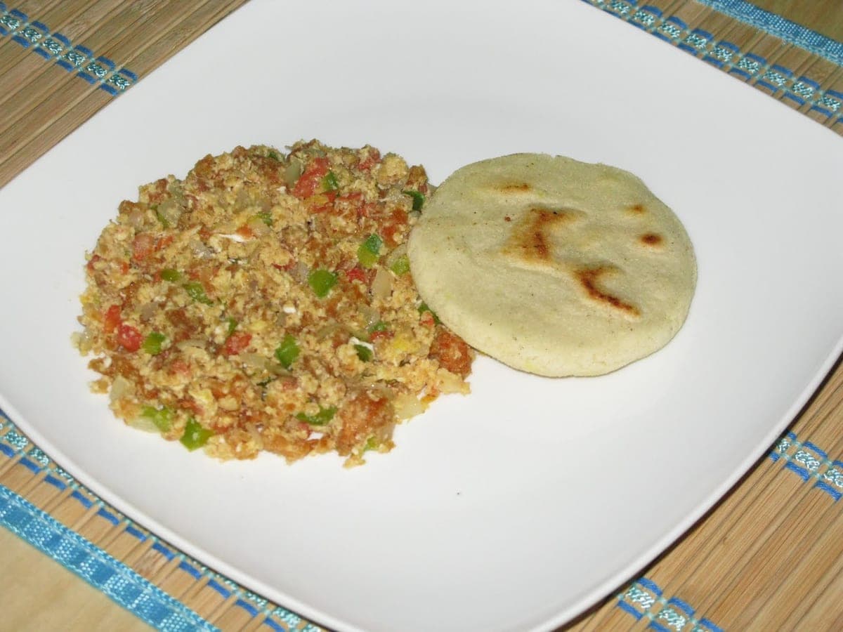 Chicharronada de huevos revueltos con chicharrón servida en un plato
