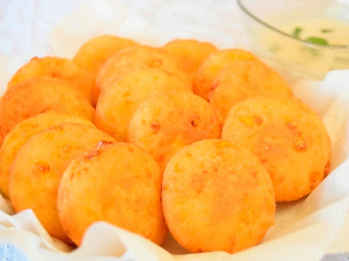 Arepitas de queso fritas, doradas y crujientes, apiladas en una cesta