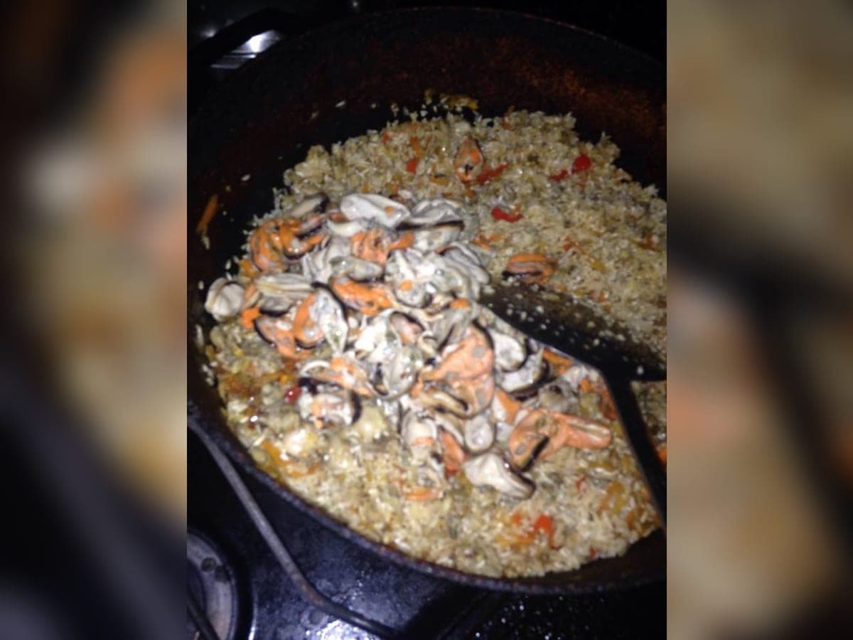 Arroz oriental con mejillones en su concha y chipichipis, adornado con cilantro