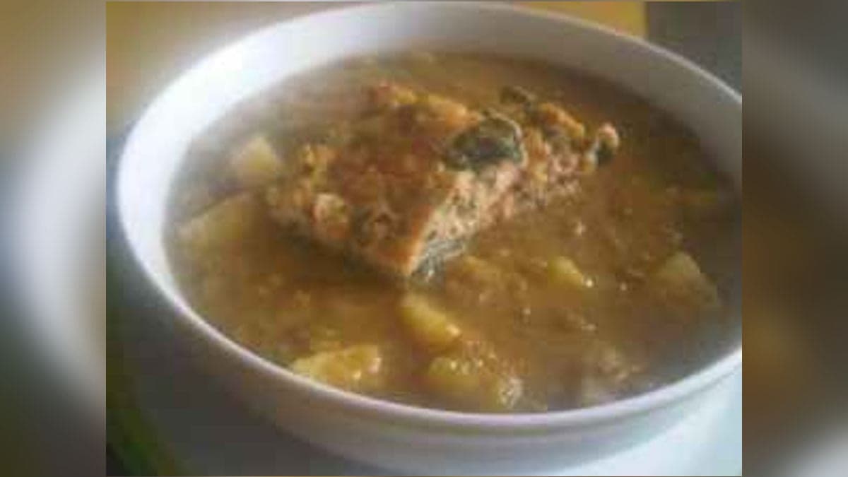 Plato de caldo de cochute espeso con papas y verduras verdes