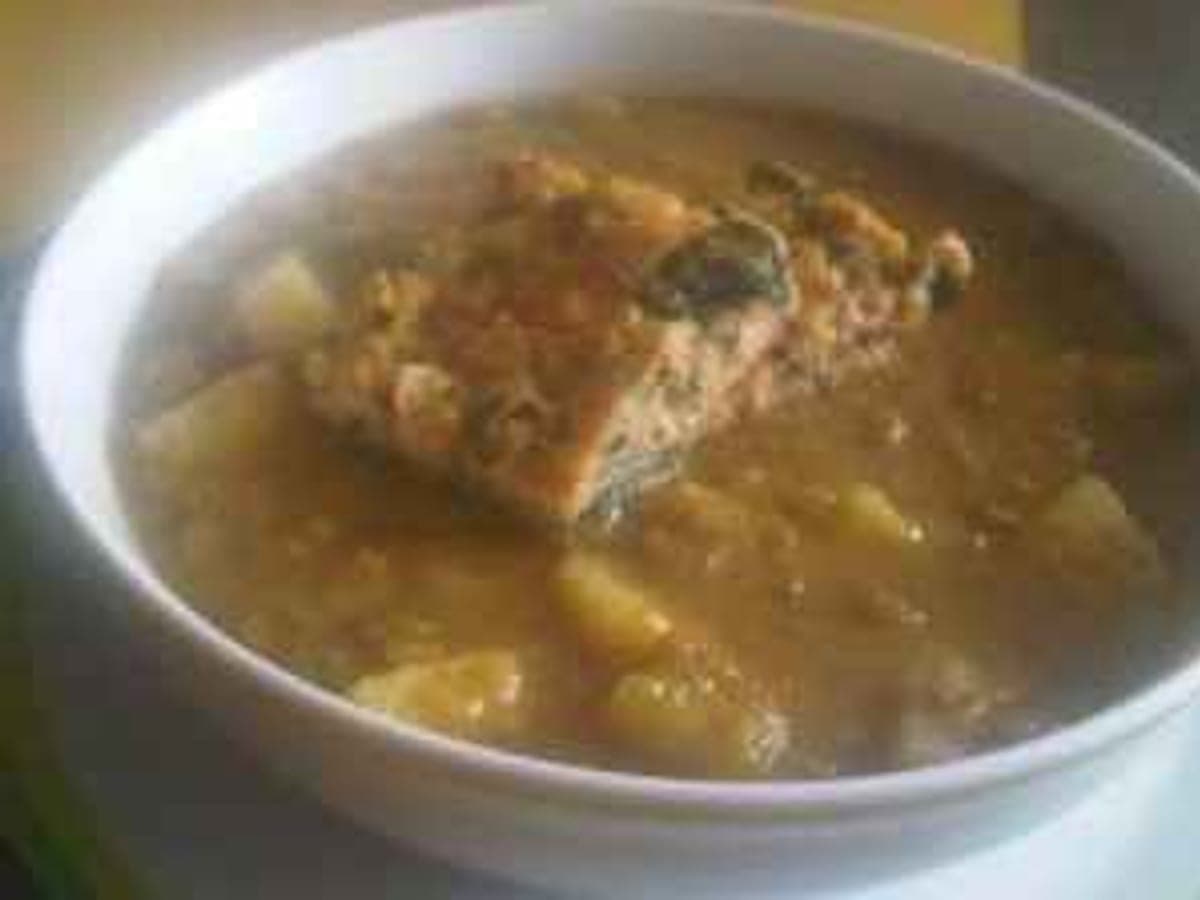 Plato de caldo de cochute espeso con papas y verduras verdes