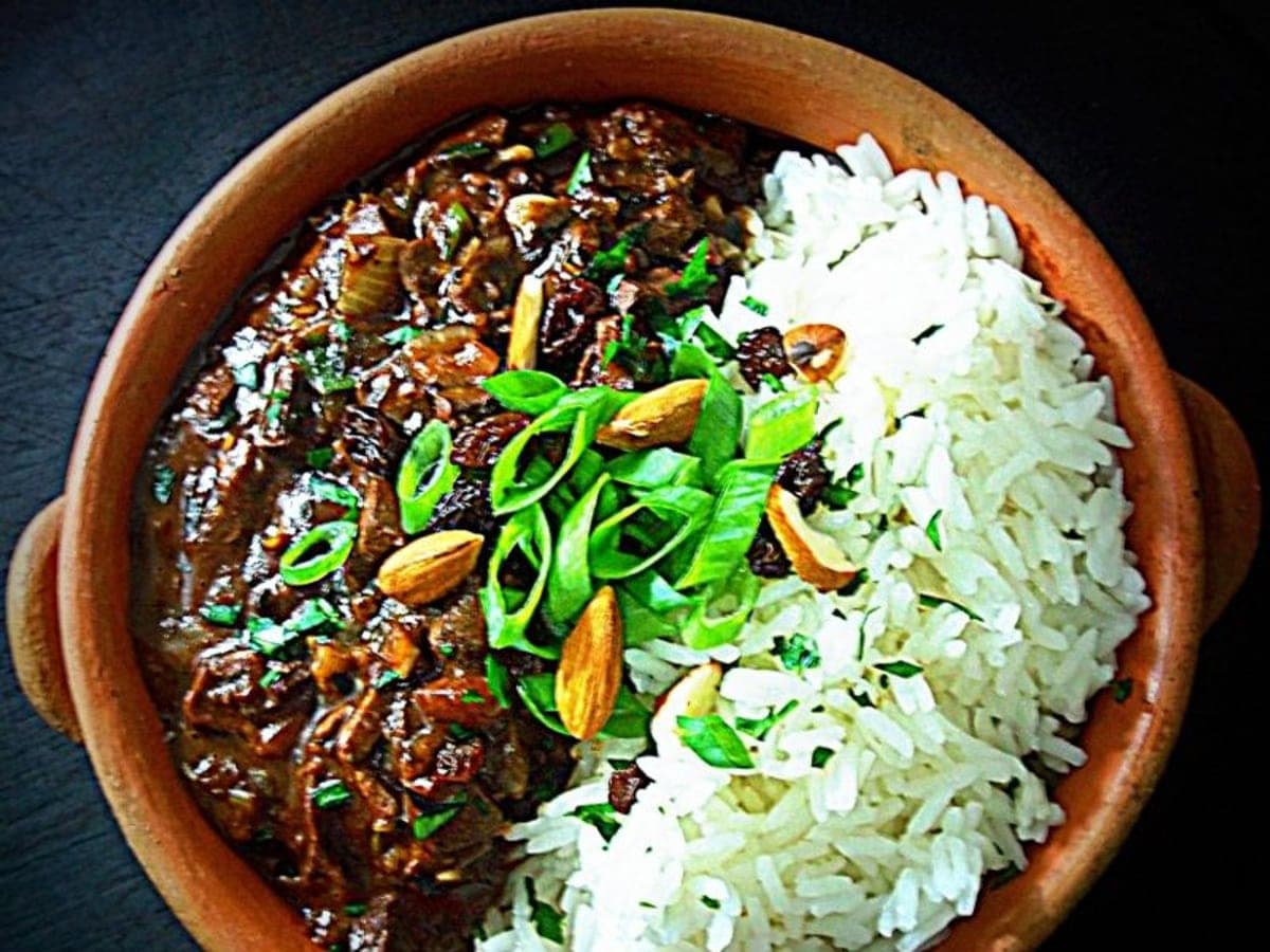 Chanfaina larense emplatada sobre un aro de arroz blanco, bañada con su salsa de papelón
