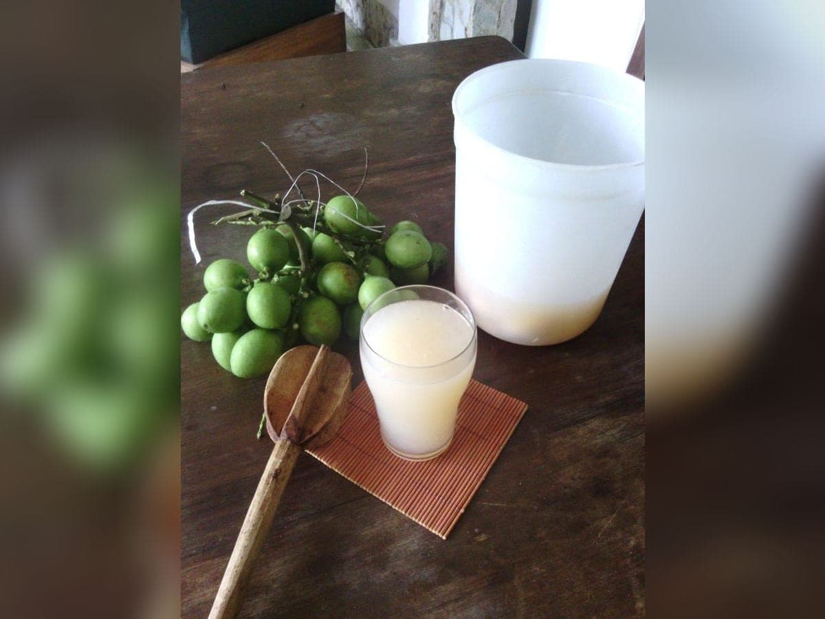 Jugo de mamón servido con hielo picadito en un vaso alto