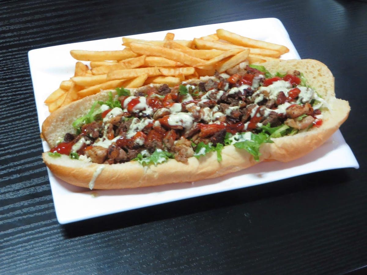 Pepito venezolano abierto, relleno de carne, lechuga, papas fritas y salsas