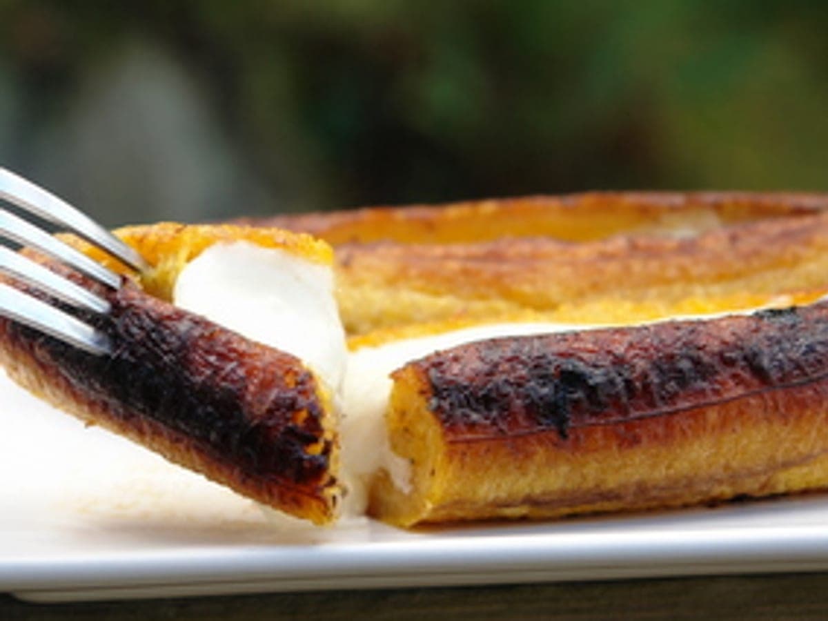 Plátanos maduros abiertos a lo largo y rellenos de queso y papelón, dorados al horno