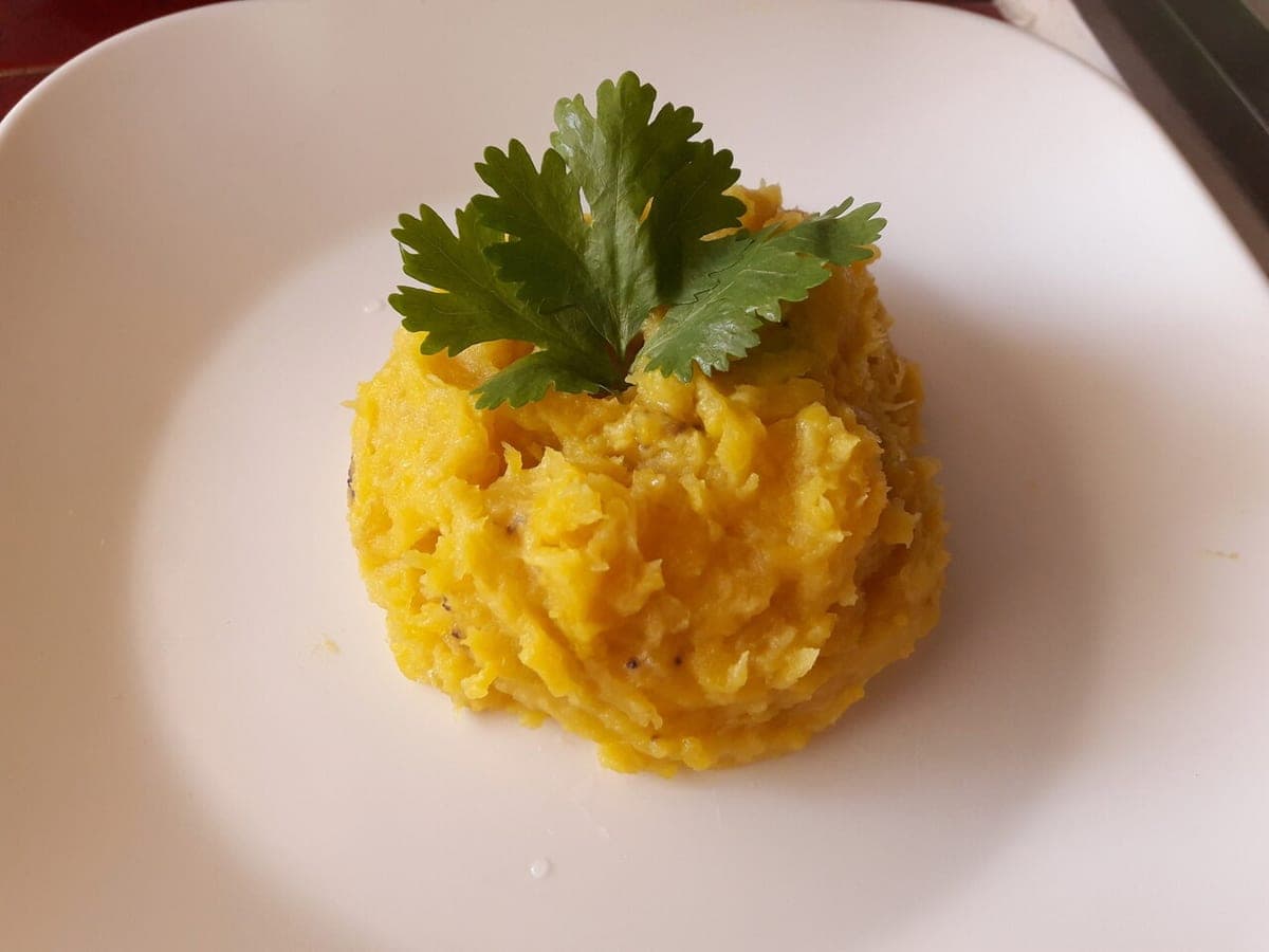 Cuenco de puré de plátano con leche de coco espolvoreado con canela