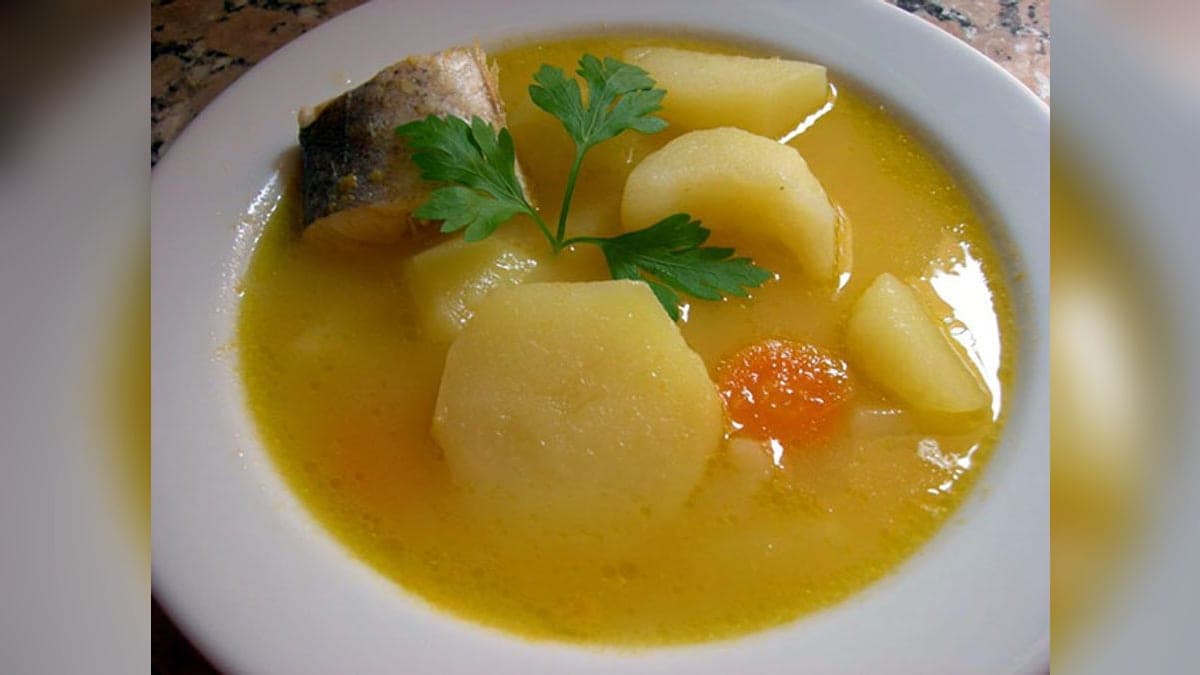 Sancocho de guaraguara servido en plato hondo, con el pescado de río entre las verduras