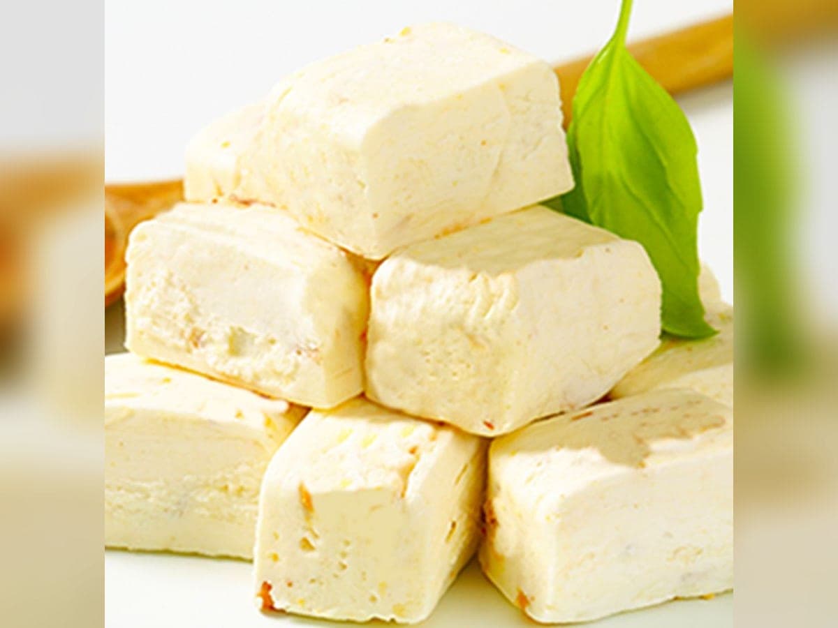 Cuadros de turrón de coco con leche cortados sobre una tabla